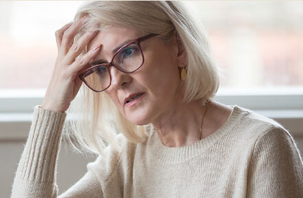 Older woman holding hand on her forehead