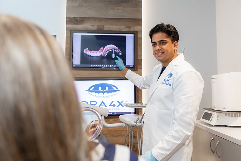 Dr. Dalla showing dental implants model on monitor