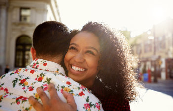 laughing happy woman hugs a man in the city center