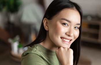 A broadly smiling middle-aged Asian woman showing her nice teeth in a smile