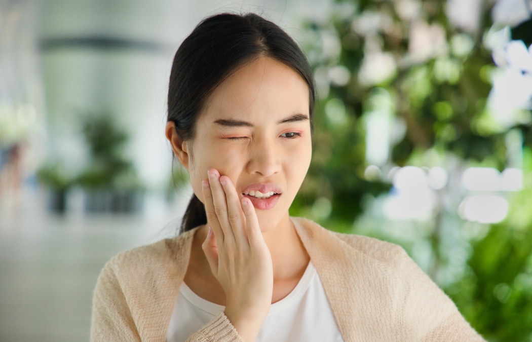 Young Asian woman suffering from toothache, tooth decay, tooth sensitivity, wisdom tooth pain, cavity, dental care concept
